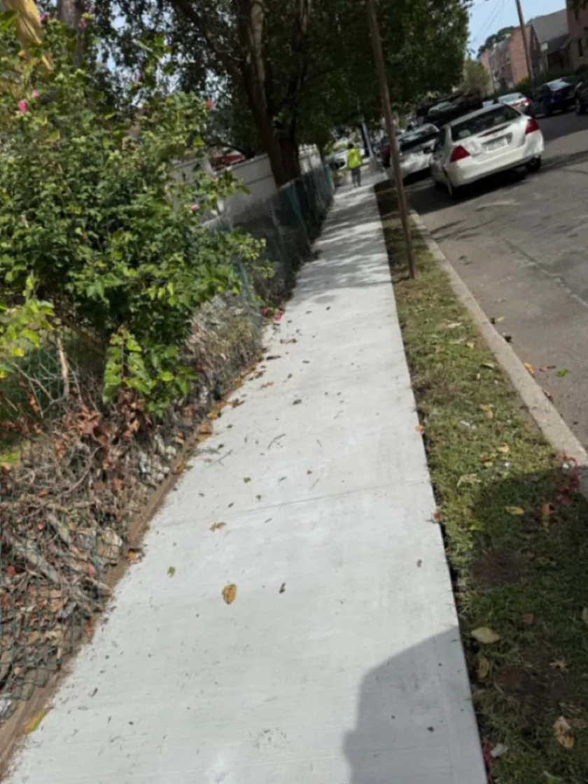 Freshly repaired concrete sidewalk with finished joints in Jamaica, Queens